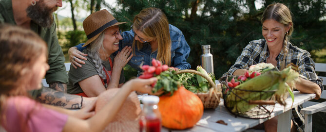 People happy around table with vegetables